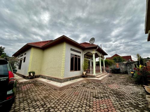 a small house with a car parked in front of it at Inshuti Home Stay in Gasanze