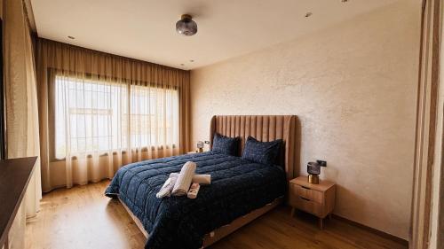 - une chambre avec un lit doté d'une couverture bleue et d'une fenêtre dans l'établissement Luxury garden loft tamaris, à Tamaris
