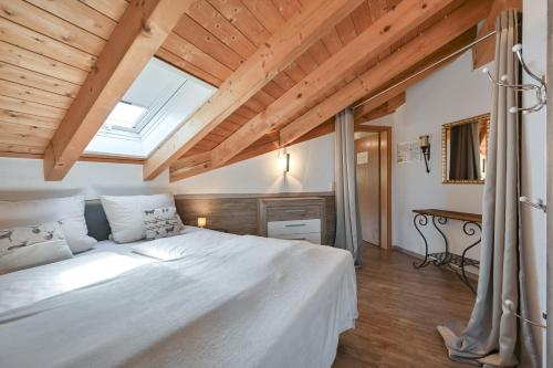 a bedroom with a large white bed with a skylight at Chalet im Haus Schlossblick in Füssen