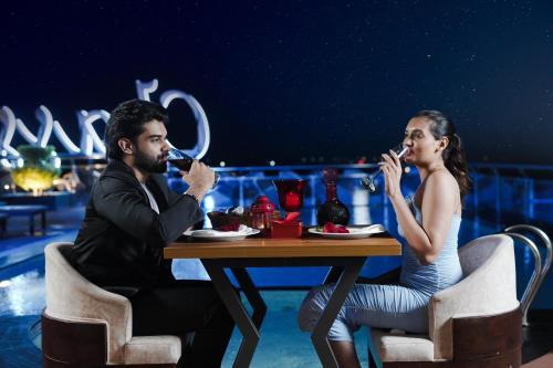 a man and woman sitting at a table drinking wine at Classic Regency in Alleppey