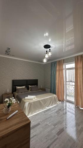 a bedroom with a large bed and a window at Квартира в Туркестане in Tridtsatʼ Let Kazakhstana