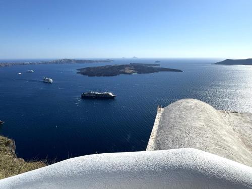 a view of a large body of water with boats at Ater Albus Collection by K&K in Imerovigli