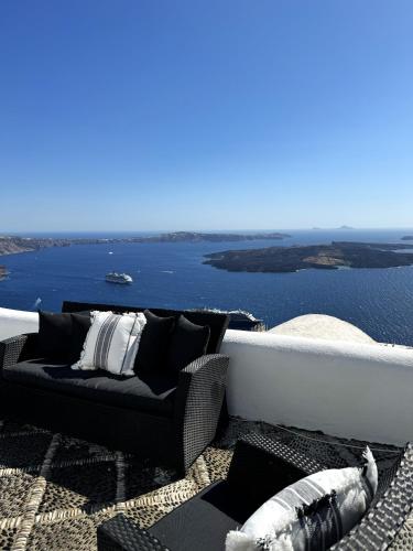 a living room with a couch and a view of the water at Ater Albus Collection by K&K in Imerovigli