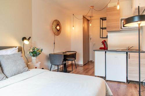 une chambre avec un lit et une cuisine avec une table dans l'établissement Lyon centre appartement meublé, à Lyon
