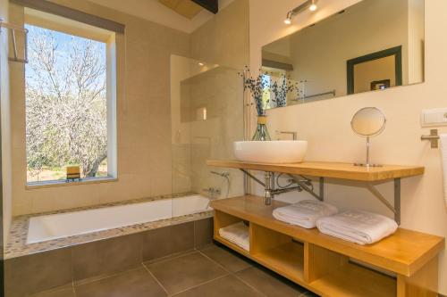baño con lavabo, bañera y ventana en Can Pere Rapinya, en Algaida