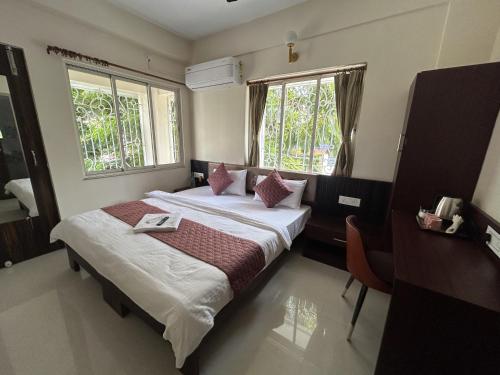 two beds in a room with two windows at Chopson's Parc in Thākurdwari