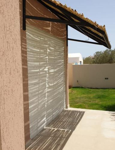 a garage door on the side of a house at Maison du Sud in Terhalla