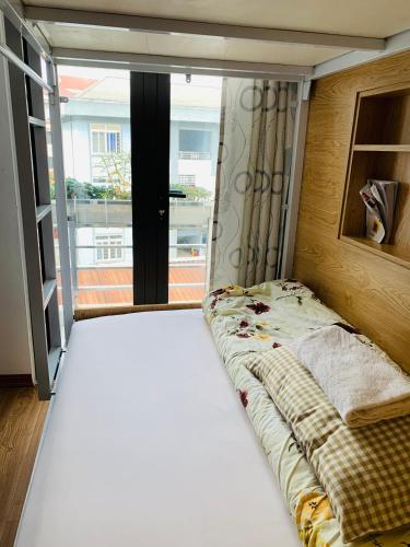 a bed in a room with a large window at Primrose Homestay Cao Bang in Cao Bằng