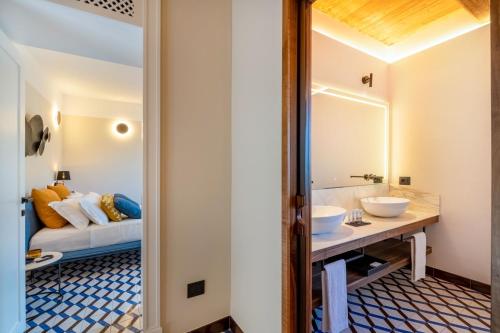 a bathroom with two sinks and a bed in the background at Gargiulo Resort in Sant'Agnello