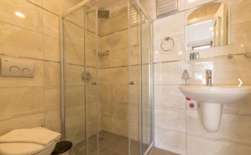 a bathroom with a shower and a toilet and a sink at KIYI SUITES Otel in Yakaköy