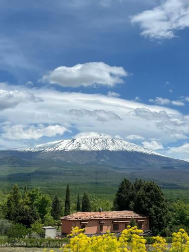a snow covered mountain in the distance with a building at Dimora dell'Etna in Randazzo