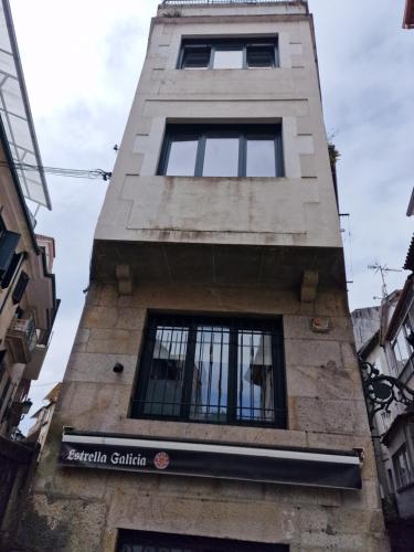 een hoog gebouw met ramen aan de zijkant bij La de Fredyy - Tres Marias Apartments in Redondela