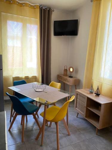 une salle à manger avec une table, des chaises et une télévision dans l'établissement 1 - Quartier des Cordiers accès funiculaire à 100m, au Tréport