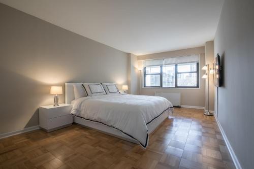 a bedroom with a bed and a large window at Spectacular 2 Beds/2 Baths Apartment in New York