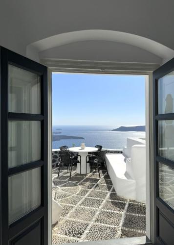 a balcony with a view of a table and chairs at Ater Albus Collection by K&K in Imerovigli