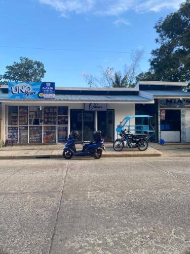 twee motorfietsen geparkeerd voor een winkel bij MV Tourist Inn in Puerto Princesa City