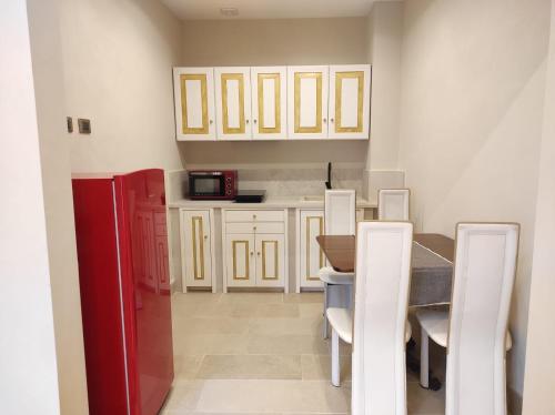 a kitchen with a table and a red refrigerator at Monte Etna Confòrt Maison in Linguaglossa