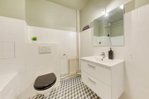 une salle de bain blanche avec des toilettes et un lavabo dans l'établissement Charmant Appartement à 10 minutes de Paris avec Balcon, à Vanves