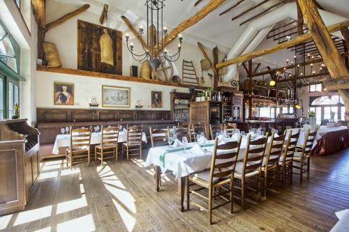 een eetkamer met tafels en stoelen en een kroonluchter bij Golfpark Gut Düneburg in Haren