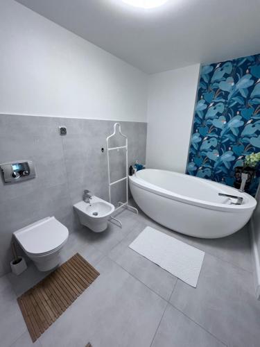 een badkamer met een bad, een toilet en een wastafel bij Apartamenty Zdrowa 6 in Ciężkowice