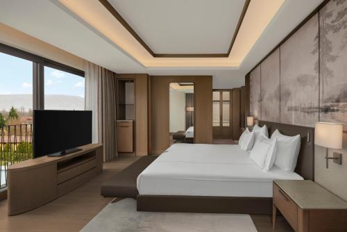 a bedroom with a bed and a flat screen tv at NG Enjoy in Sapanca