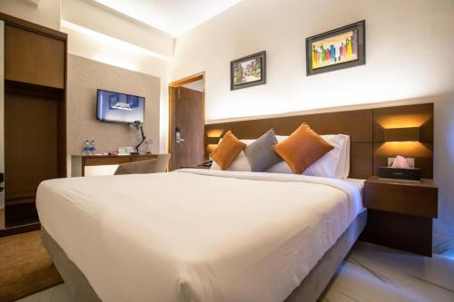 a bedroom with a large white bed in a room at Jatra Flagship Chattogram City Centre in Chittagong