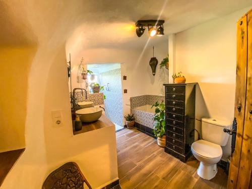 een badkamer met een toilet, een wastafel en een bad bij Cueva Ventica in Benamaurel