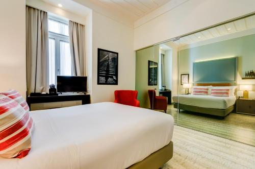 um quarto de hotel com uma cama grande e uma secretária em Vincci Baixa em Lisboa