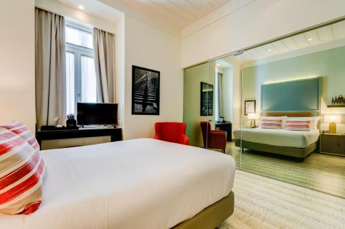 a hotel room with a large bed and a desk at Vincci Baixa in Lisbon