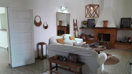 Una sala de estar con un sofá blanco y una chimenea. en Casa amplia y confortable, totalmente amoblada, quincho con asador, excelente ubicación, en Santiago del Estero