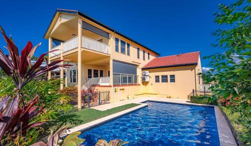 a house with a swimming pool in front of it at Buena Vista - Luxe 4 bedroom house, Views, Beach in Yeppoon