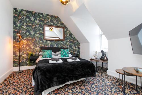 a bedroom with a large bed with a floral wallpaper at Carlton Hotel in Forres