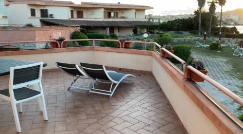 a patio with chairs and a table on a balcony at Case sul mare in Palau