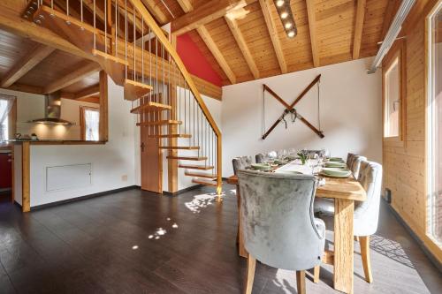 a dining room with a table and chairs and a staircase at Chalet Lauterbrunnen in Lauterbrunnen
