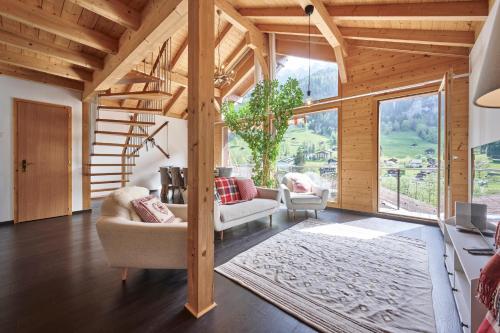 a living room with wooden ceilings and a large window at Chalet Lauterbrunnen in Lauterbrunnen