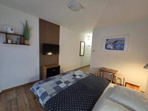 una camera da letto con un letto e una televisione di Pensjonat Amber a Pobierowo