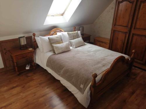 een slaapkamer met een bed met kussens en een raam bij NormanD Holiday Home - VIRE CALVADOS Relaxing Rural Retreat in Le Reculey