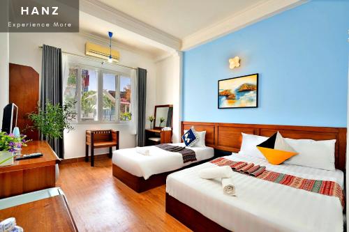 a hotel room with two beds and a desk at HANZ Hotel upstair MPChill in Ho Chi Minh City