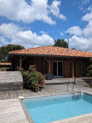 une maison avec une piscine devant une maison dans l'établissement Maison bois chez M&D, à Lège-Cap-Ferret