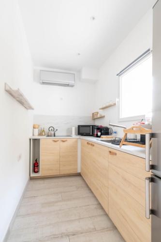 - une cuisine avec des murs blancs et des placards en bois dans l'établissement Studio à 5 min de l' aéroport et toutes commodités, à Saint-Victoret