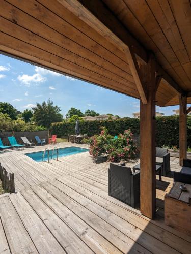 une terrasse en bois avec une piscine et une pergola en bois dans l'établissement Maison bois chez M&D, à Lège-Cap-Ferret