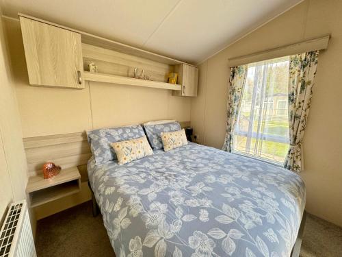 een kleine slaapkamer met een bed en een raam bij Sweet Pea Pet Friendly Lodge in South Cerney