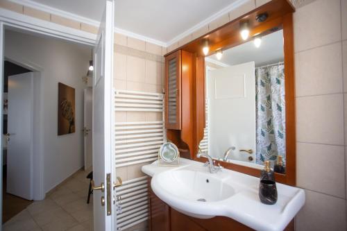 uma casa de banho com um lavatório e um espelho em Socrates by Heloni Apartments em Atenas