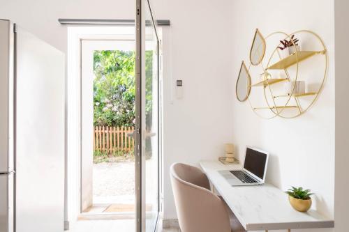 Cette chambre blanche dispose d'un bureau avec un ordinateur portable. dans l'établissement Studio à 5 min de l' aéroport et toutes commodités, à Saint-Victoret