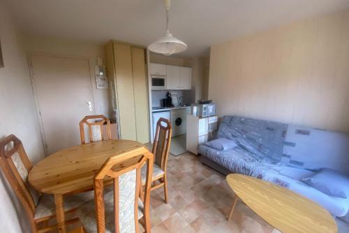 une petite chambre avec une table à manger et une cuisine dans l'établissement Cozy apartment at the foot of the beach, à Ouistreham