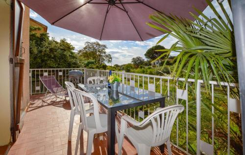 une table et des chaises sur un balcon avec un parasol dans l'établissement 2 Bedroom Stunning Home In San-Giuliano, à San-Giuliano
