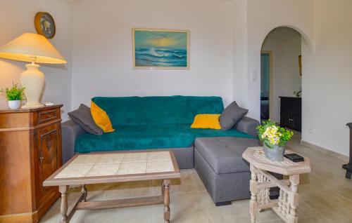 un salon avec un canapé vert et une table dans l'établissement 2 Bedroom Stunning Home In San-Giuliano, à San-Giuliano