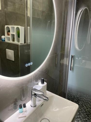 La salle de bains est pourvue d'un lavabo avec miroir et d'une douche. dans l'établissement Studio plein centre CARRÉ D’OR, à Nice