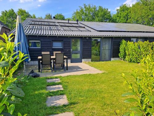 a house with a table and chairs in a yard at De Platwever 3B in Zelhem