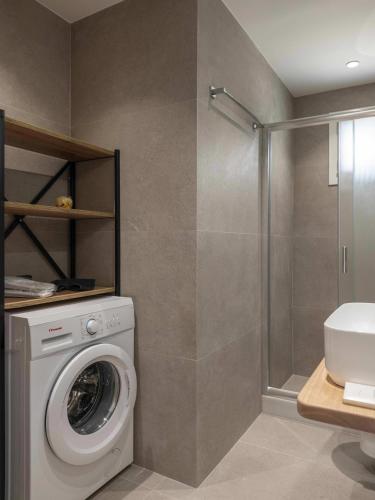 a bathroom with a washing machine and a shower at Parikia's Urban Oasis in Parikia